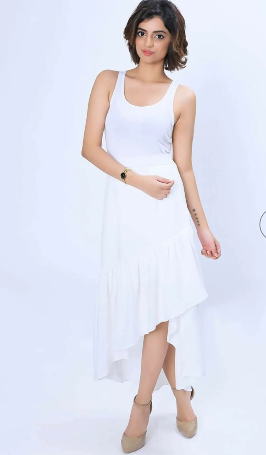 Zara Shafiq Khan in a white dress, studio editorial